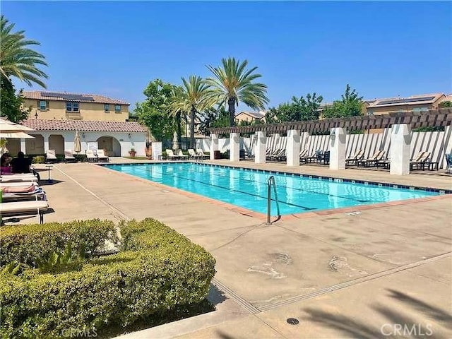 community pool with fence and a patio area