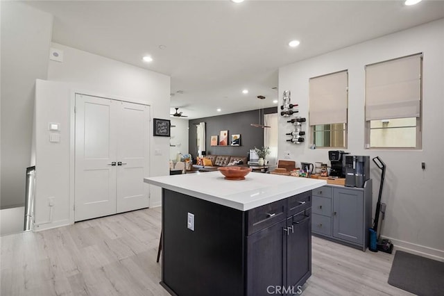 kitchen with a center island, ceiling fan, light countertops, recessed lighting, and light wood-style floors