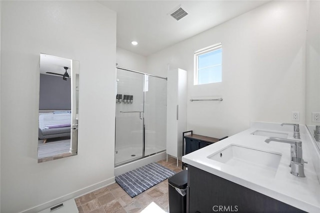 ensuite bathroom featuring a stall shower, visible vents, and a sink