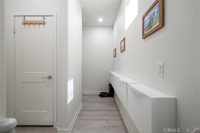 hall with baseboards and light wood-style flooring