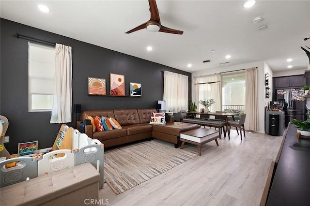 living area with light wood finished floors, plenty of natural light, recessed lighting, and ceiling fan