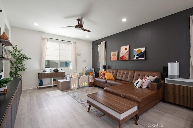 living area with wood finished floors, baseboards, radiator heating unit, recessed lighting, and ceiling fan