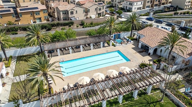 community pool with a residential view, a patio, and fence