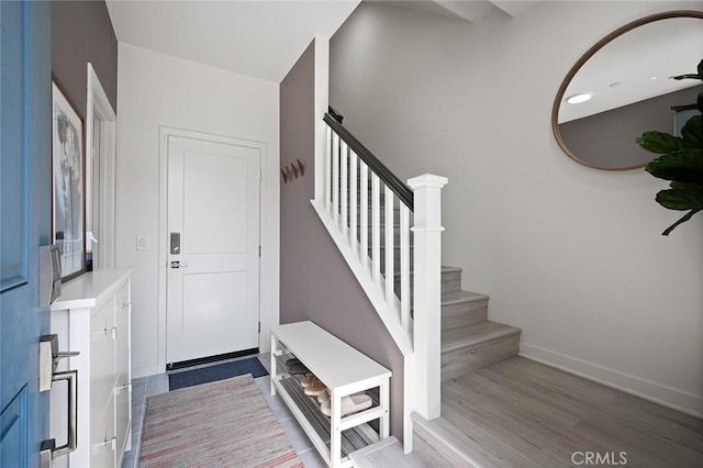 entrance foyer with stairway, baseboards, and wood finished floors