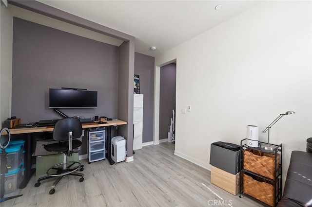 office space with light wood-type flooring and baseboards