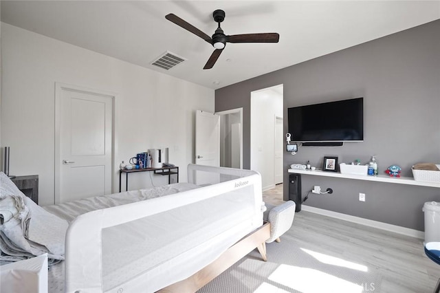 bedroom featuring visible vents, ceiling fan, baseboards, and wood finished floors