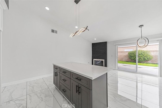 kitchen featuring visible vents, a kitchen island, baseboards, light countertops, and marble finish floor