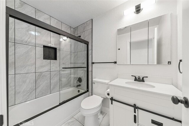 bathroom featuring toilet, vanity, combined bath / shower with glass door, marble finish floor, and a textured ceiling