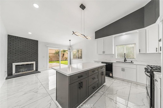 kitchen with a sink, marble finish floor, black appliances, and white cabinets