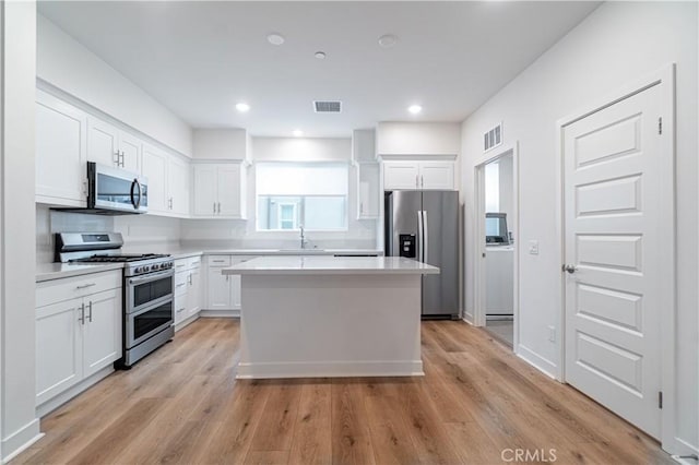 kitchen featuring white cabinets, visible vents, appliances with stainless steel finishes, and a sink