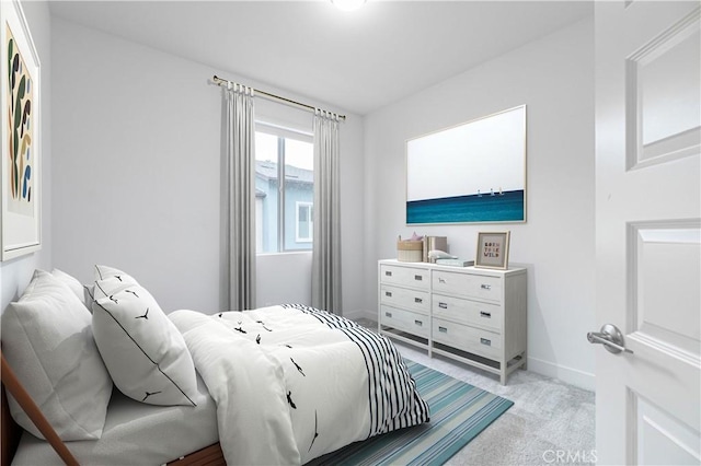 bedroom with baseboards and light colored carpet