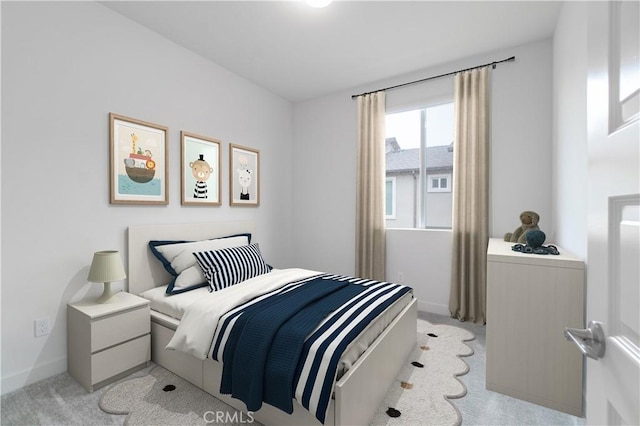 bedroom with light colored carpet and baseboards