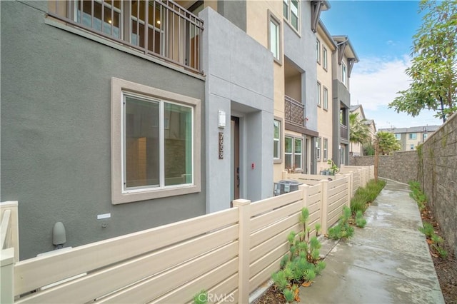 view of property exterior featuring a residential view, stucco siding, and a fenced backyard