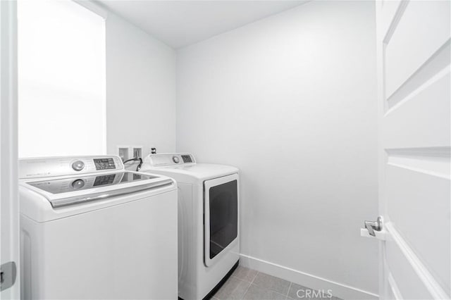 laundry area featuring laundry area, light tile patterned floors, baseboards, and washing machine and clothes dryer