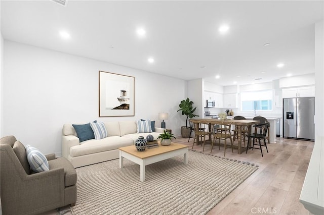 living area featuring recessed lighting and light wood-style floors