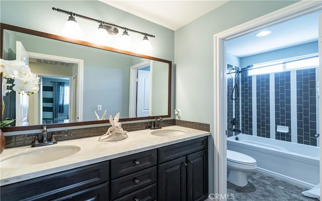 bathroom featuring double vanity, toilet, bathtub / shower combination, and a sink