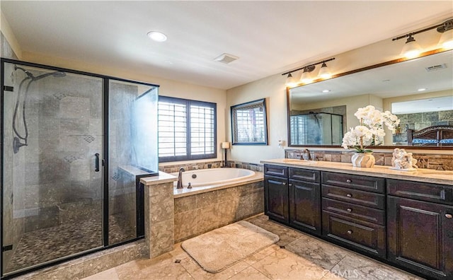 bathroom featuring visible vents, a sink, a shower stall, double vanity, and a bath