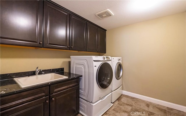 laundry area featuring a sink, visible vents, cabinet space, and washer and clothes dryer