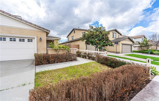 view of front of property featuring stucco siding, driveway, and fence