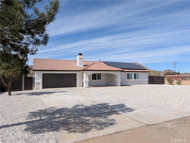 single story home with fence, a tile roof, stucco siding, driveway, and an attached garage