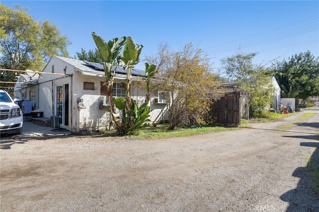 view of property exterior with solar panels and stucco siding