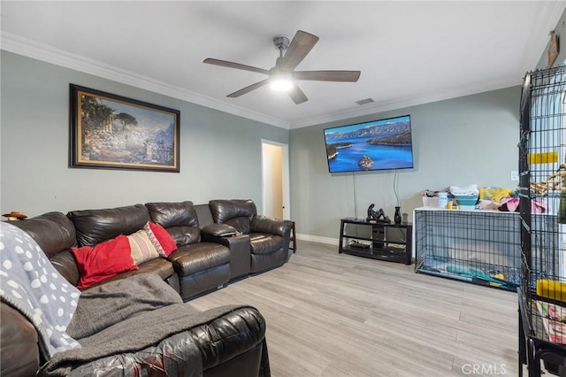 living room featuring visible vents, baseboards, ornamental molding, wood finished floors, and a ceiling fan