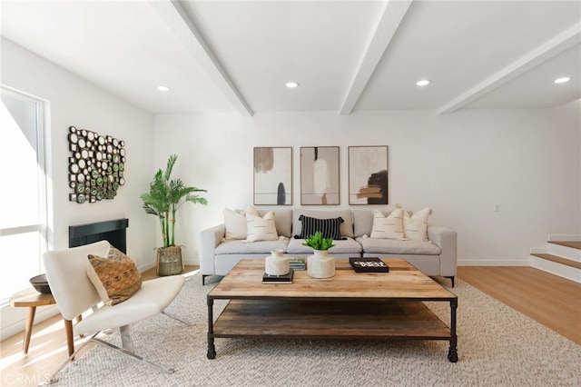 living area with wood finished floors, baseboards, recessed lighting, stairs, and beamed ceiling