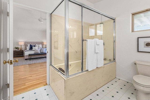 full bath with toilet, baseboards, and bath / shower combo with glass door