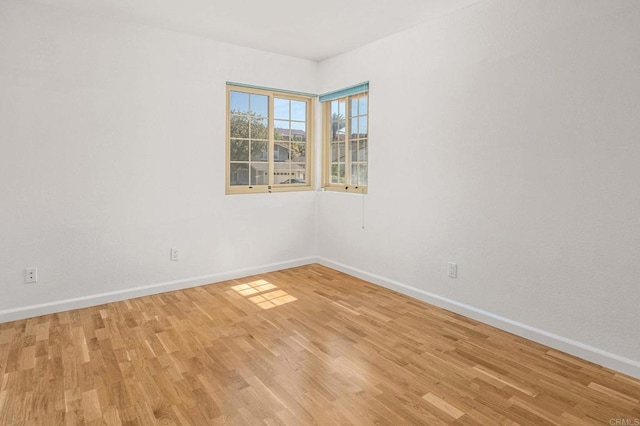 empty room with light wood-style flooring and baseboards