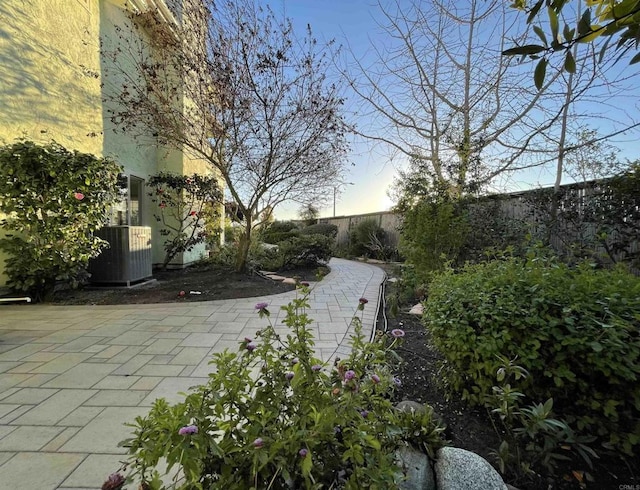 view of patio with central air condition unit and fence