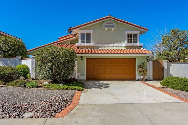 mediterranean / spanish house featuring stucco siding, a garage, concrete driveway, and a tile roof