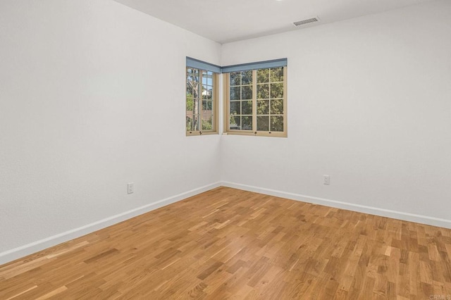 unfurnished room with visible vents, baseboards, and light wood-style floors