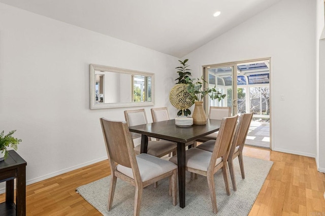 dining room featuring a wealth of natural light, lofted ceiling, and light wood-style floors