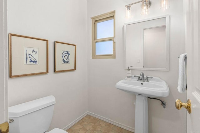 bathroom featuring toilet and baseboards