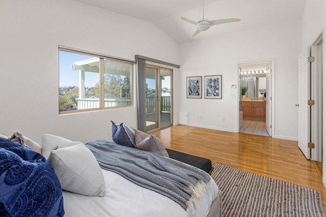 bedroom featuring lofted ceiling, access to outside, ensuite bath, wood finished floors, and baseboards