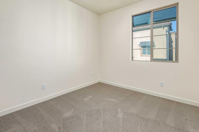 carpeted empty room with baseboards