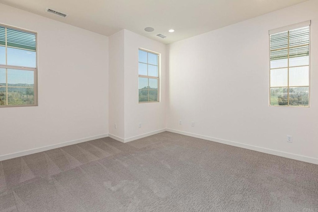 empty room with visible vents, recessed lighting, baseboards, and carpet floors