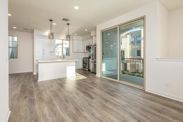 kitchen featuring wood finished floors, visible vents, appliances with stainless steel finishes, and a sink