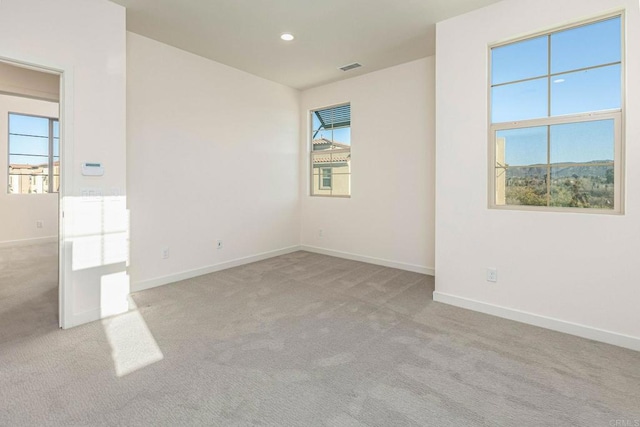 carpeted empty room featuring visible vents, recessed lighting, and baseboards