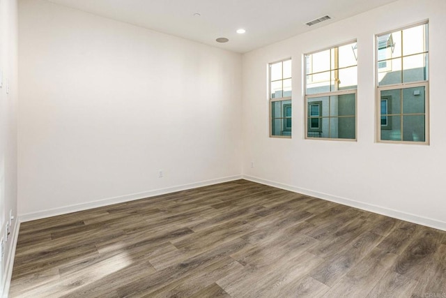 spare room with recessed lighting, dark wood-style floors, visible vents, and baseboards