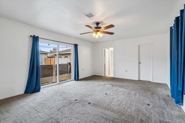 spare room with carpet, visible vents, and ceiling fan