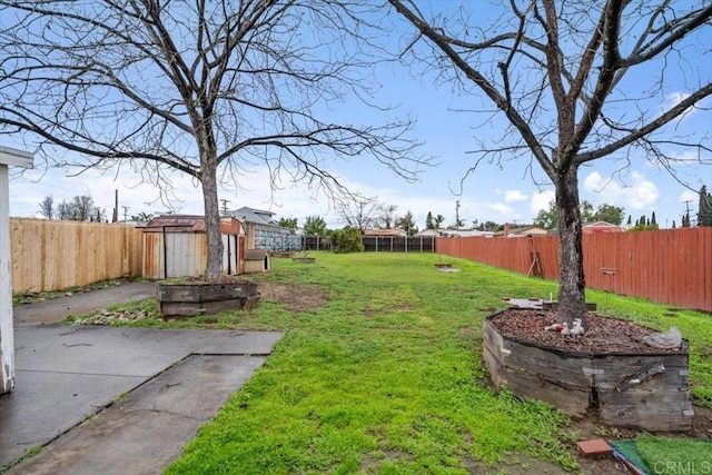 view of yard featuring an outbuilding, a fenced backyard, and a shed