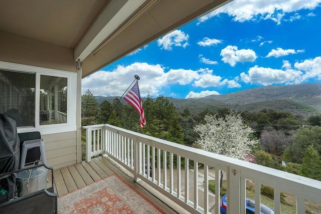 balcony featuring a mountain view and a view of trees