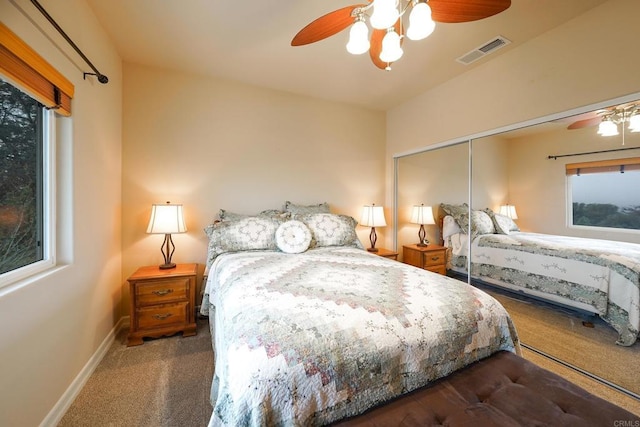 carpeted bedroom with visible vents, baseboards, a closet, and ceiling fan