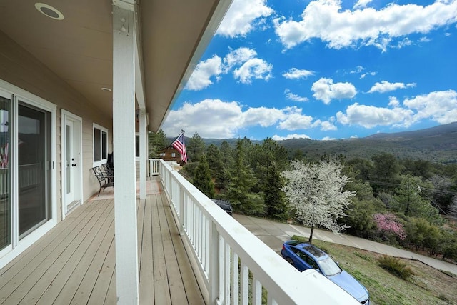 deck with a view of trees and a mountain view