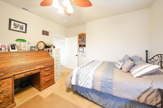 bedroom featuring a ceiling fan, visible vents, and light carpet