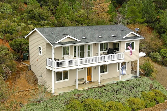 back of property featuring a patio area and roof with shingles