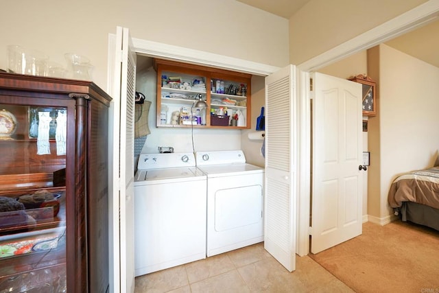 laundry area featuring independent washer and dryer, light tile patterned flooring, and laundry area