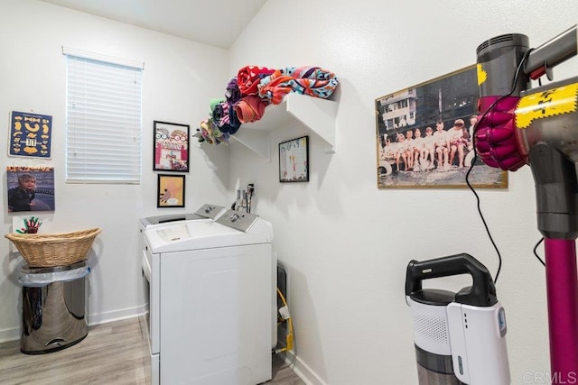 laundry area with baseboards, wood finished floors, laundry area, and washing machine and clothes dryer