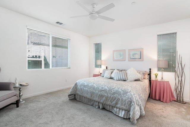 carpeted bedroom featuring visible vents, a ceiling fan, and baseboards